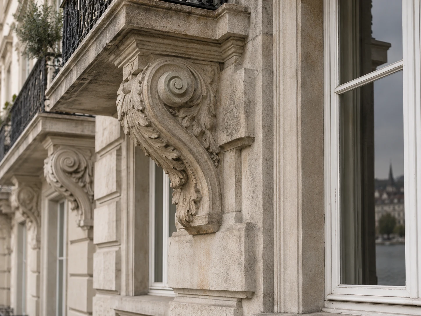 Carved sandstone balcony support beside a tall timber-framed window