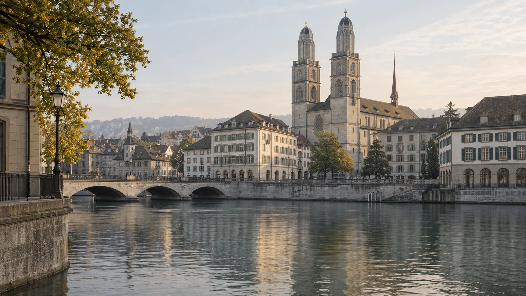 Twin towers of the Grossmünster above a stone bridge and the Limmat